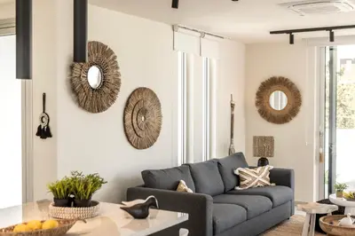 a living room with a couch and mirrors on the wall at Protaras Leomi Seaview Villa in Protaras