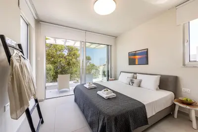 a bedroom with a bed and a large window at Protaras Leomi Seaview Villa in Protaras