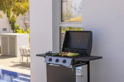 a kitchen with a grill with vegetables on it at Protaras Leomi Seaview Villa in Protaras