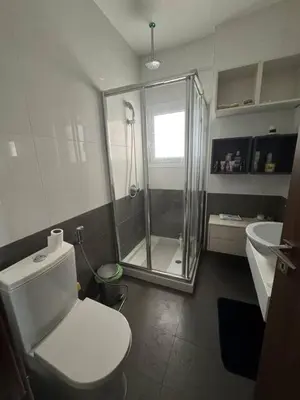 a white bathroom with a shower and a toilet at 3 bedroom seafront apartment in Limassol