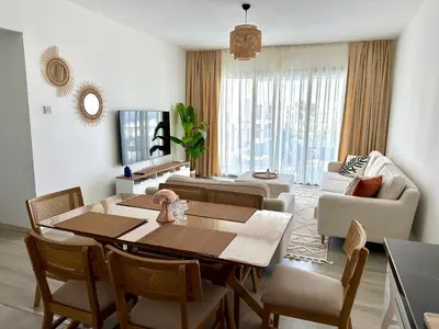 a living room with a dining room table and chairs at Bohemian penthouse in Girne Alsancak, close to Merit hotels in Kérynia