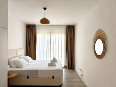 a bedroom with a bed with a mirror and a window at Bohemian penthouse in Girne Alsancak, close to Merit hotels in Kérynia