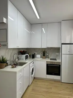a white kitchen with white cabinets and a dishwasher at Trinity Getaway in Paralimni