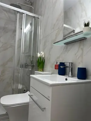 a white bathroom with a sink and a shower at Trinity Getaway in Paralimni