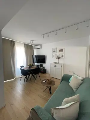 a living room with a green couch and a table at Trinity Getaway in Paralimni