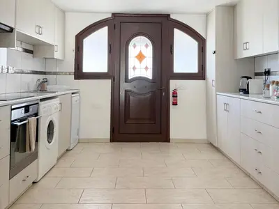 a kitchen with a brown door with a window at 5-Min Walk to Beach - Bright 2-BR Home with Private Garden & Sunset Views in Voroklini