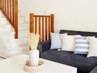 a living room with a couch and a table at 5-Min Walk to Beach - Bright 2-BR Home with Private Garden & Sunset Views in Voroklini