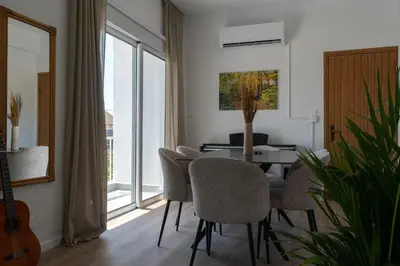 a living room with a dining room table and chairs at Limassol Sunbliss by Staycom in Limassol