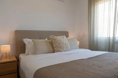a bedroom with a large bed with white sheets and pillows at Limassol Sunbliss by Staycom in Limassol