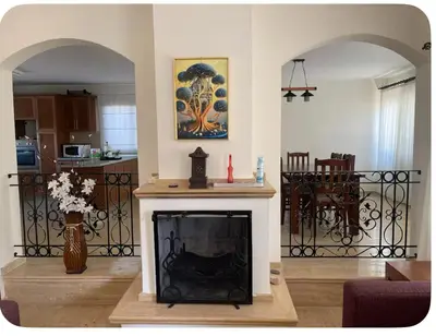 a living room with a fireplace and a kitchen at A Spacious Villa to Entertain in Aglantzia