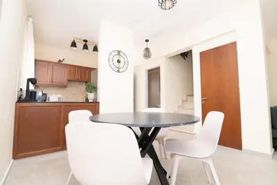 a kitchen and dining room with a table and white chairs at Malama 2 Villa Ekaterina 2 bedroom in Paralimni