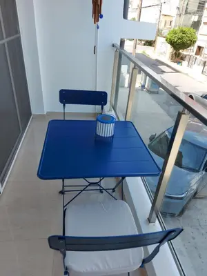 a blue table and a chair on a balcony at Bird's Nest, close to EMU, in the city center in Dherinia