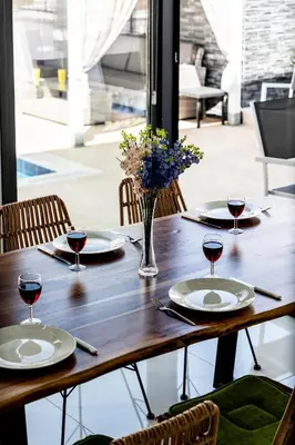 a wooden table with plates and glasses of wine at Villa Alassia 16 by Ezoria Villas in Paralimni