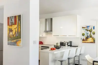 a white kitchen with white cabinets and white chairs at Protaras Seaside Villa Narcissos 16 in Protaras