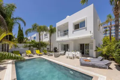 a villa with a swimming pool and palm trees at Protaras Seaside Villa Narcissos 16 in Protaras