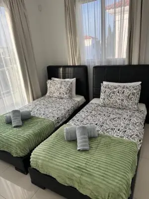 two beds sitting next to each other in a bedroom at Villa Samantha in Paralimni