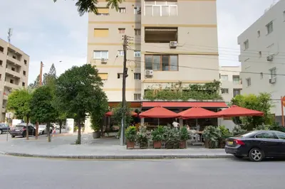 a restaurant with red umbrellas in front of a building at Central 1BR - Views - Deli Café in Nicosia