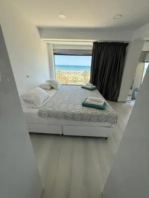 a bedroom with a bed and a large window at Marimar2 paradise by the Sea in Larnaka