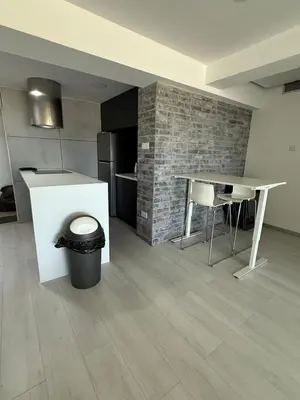 a kitchen with a counter and a table and a trash can at Marimar2 paradise by the Sea in Larnaka