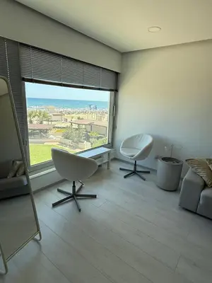 a living room with two chairs and a large window at Marimar2 paradise by the Sea in Larnaka