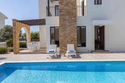 a villa with a swimming pool and a house at Ionion H30 in Ayia Napa