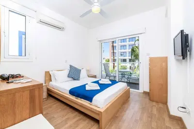 a bedroom with a bed and a tv and a balcony at Villa Atlantis in Protaras