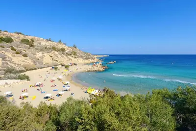 a beach with a bunch of people and the ocean at Villa Atlantis in Protaras