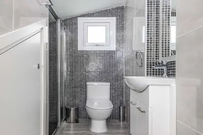 a white bathroom with a toilet and a sink at Green Bay Villa 15 in Protaras