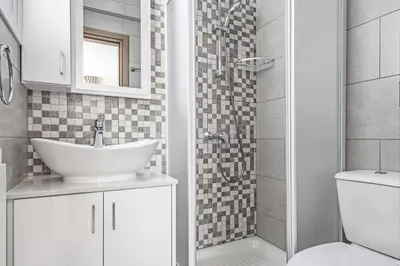 a white bathroom with a sink and a shower at Green Bay Villa 15 in Protaras