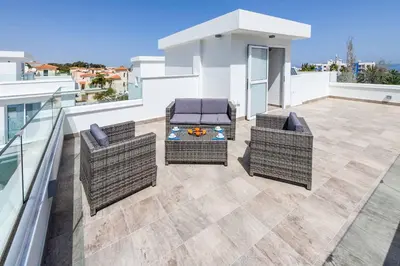 a patio with two chairs and a table on a balcony at Green Bay Villa 15 in Protaras
