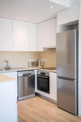 a kitchen with stainless steel appliances and white cabinets at CasaMar - Upscale One-Bedroom Apartment by the Sea in Larnaka