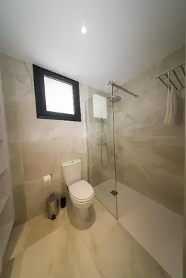 a bathroom with a toilet and a shower and a window at CasaMar - Upscale One-Bedroom Apartment by the Sea in Larnaka