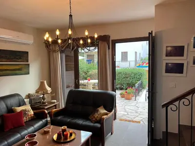 a living room with a couch and a chandelier at Αετοφωλιά-AETOFOLIA in Pano Lefkara