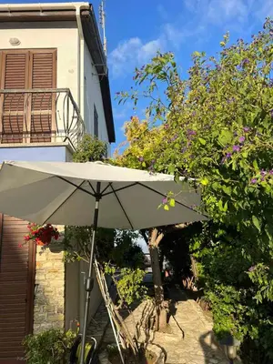 a white umbrella sitting in front of a building at Αετοφωλιά-AETOFOLIA in Pano Lefkara