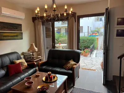a living room with a couch and a chandelier at Αετοφωλιά-AETOFOLIA in Pano Lefkara