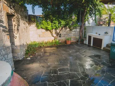 a stone patio with a sink and a tree at Revecca House in Ayios Mamas
