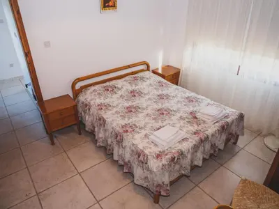 a bedroom with a bed with a floral bedspread at Revecca House in Ayios Mamas
