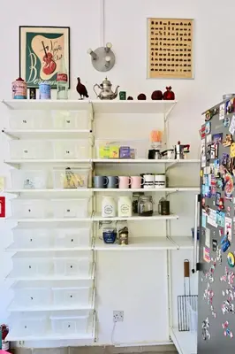 a white pantry with white shelves and a refrigerator at Lemongrass Hostel in Limassol