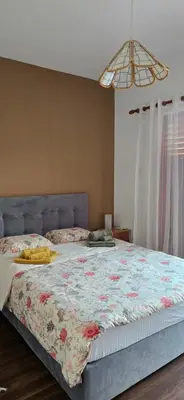 a bedroom with a large bed with a floral blanket at Barefoot Beach House in Larnaka