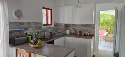 a kitchen with white cabinets and a counter top at Barefoot Beach House in Larnaka