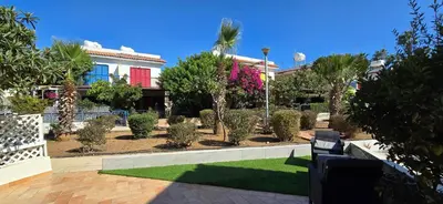 a house with a yard with a lawn and trees at Barefoot Beach House in Larnaka