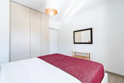 a bedroom with a white bed and a mirror at Sunny & Stylish City Centre Living in Nicosia