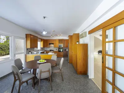 a kitchen and dining room with a table and chairs at Pervolia Nirides Seaside Mansion 7 in Larnaka