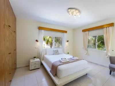 a bedroom with a white bed and two windows at Pervolia Nirides Seaside Mansion 7 in Larnaka