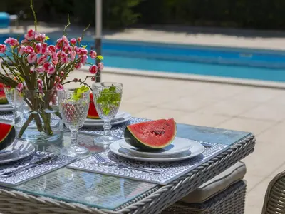 a table with a plate of watermelon on it at Pervolia Nirides Seaside Mansion 7 in Larnaka