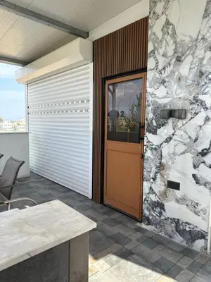 a house with a wooden door and a stone wall at Costas court in Limassol