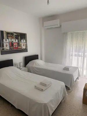 a room with two beds with white sheets and a window at Charming 2 Bdr Nicosia Apt Free Parking & Wi-Fi in Nicosia