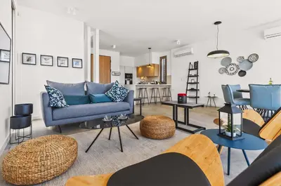 a living room with a blue couch and chairs at Azure Sama Villa in Protaras