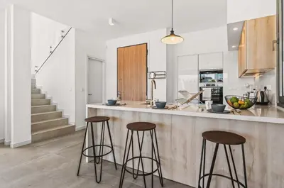 a kitchen with two bar stools and a counter at Azure Sama Villa in Protaras