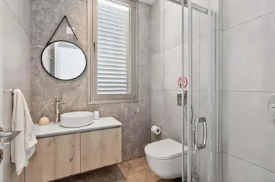 a bathroom with a toilet and a sink and a mirror at Azure Leda Villa in Protaras